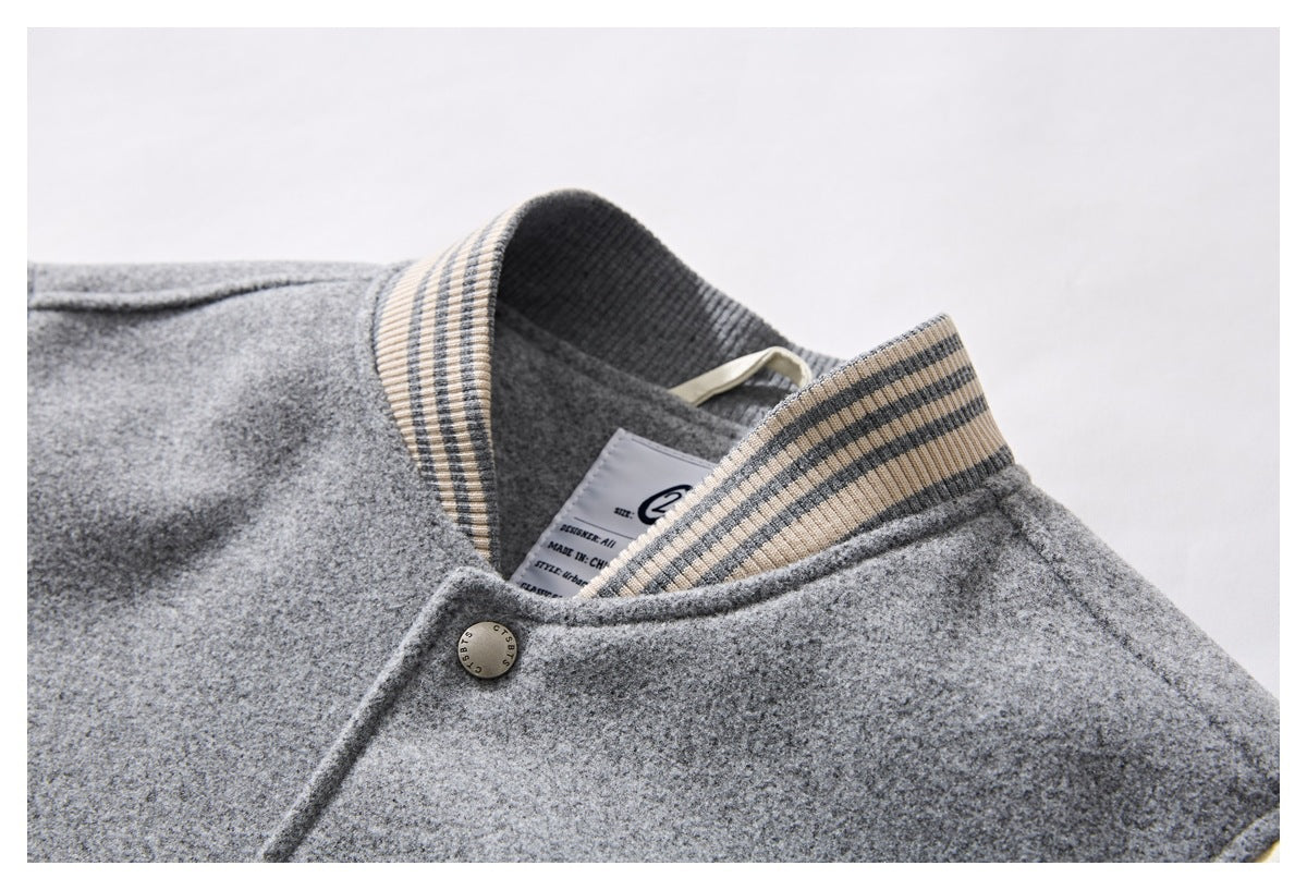Close-up of the gray garment's striped ribbed collar and inner neck label.