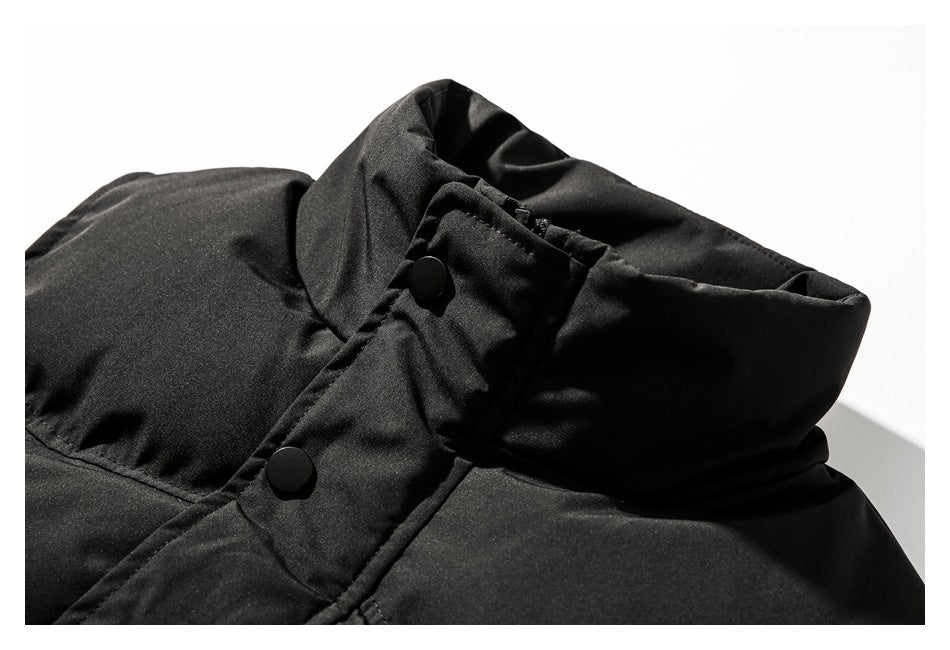 Close-up of a black jacket’s tall collar and snap-button front placket.
