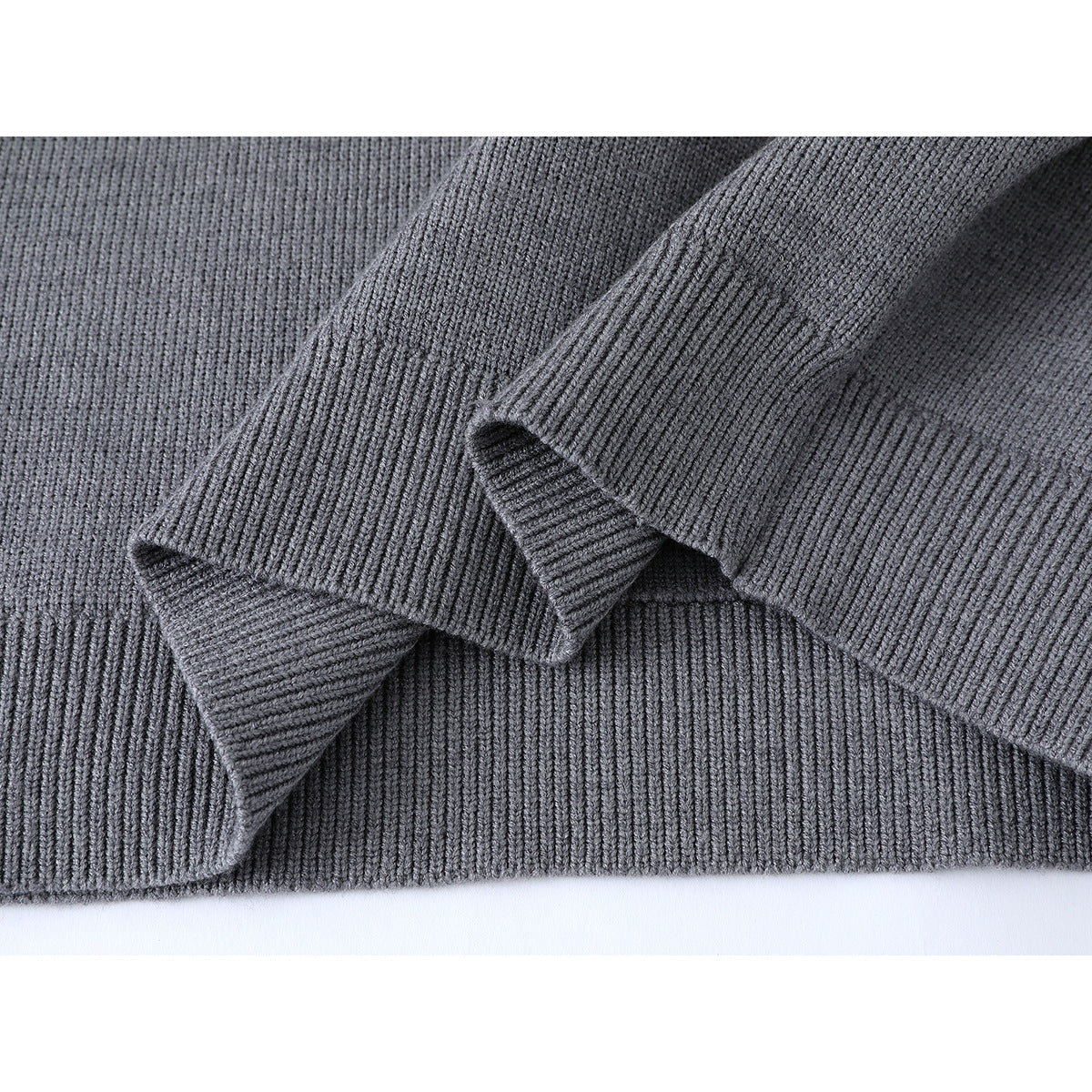 Close-up of the gray sweater's ribbed sleeve cuff and knit fabric.