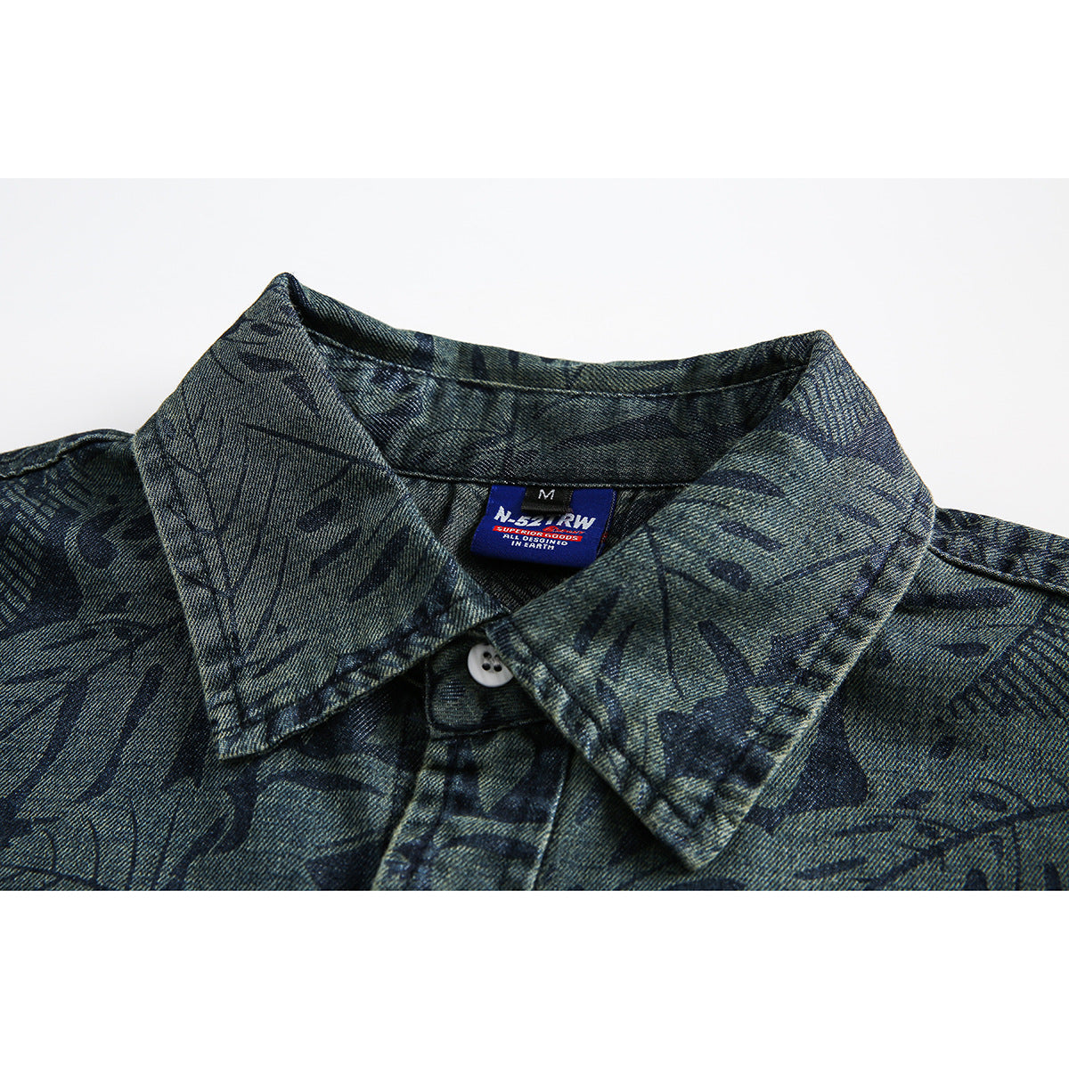 Close-up of a dark blue-gray patterned shirt collar, white button, and inner English-language brand label.