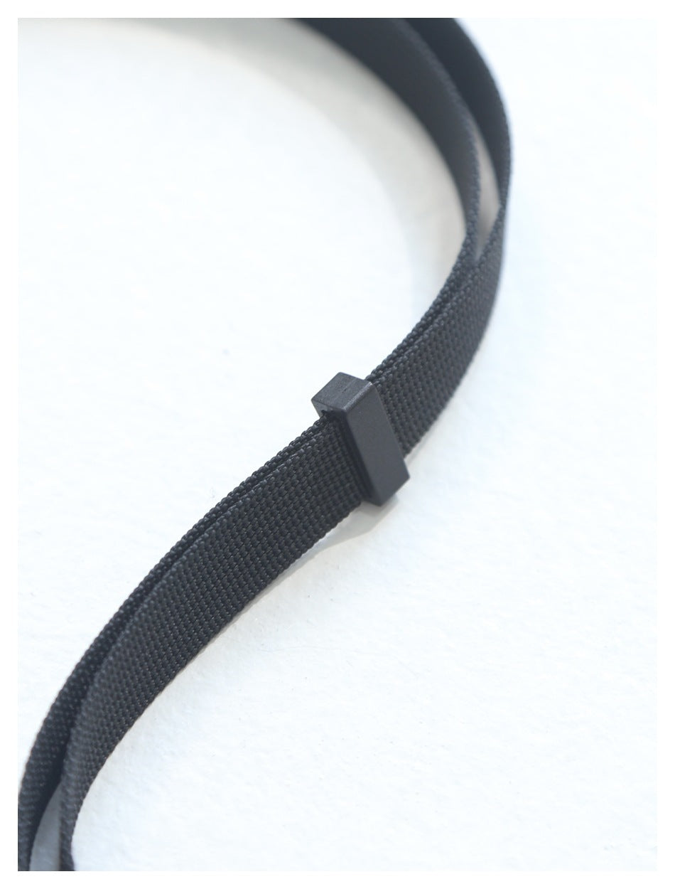 Close-up of a black woven strap threaded through a rectangular black slider.