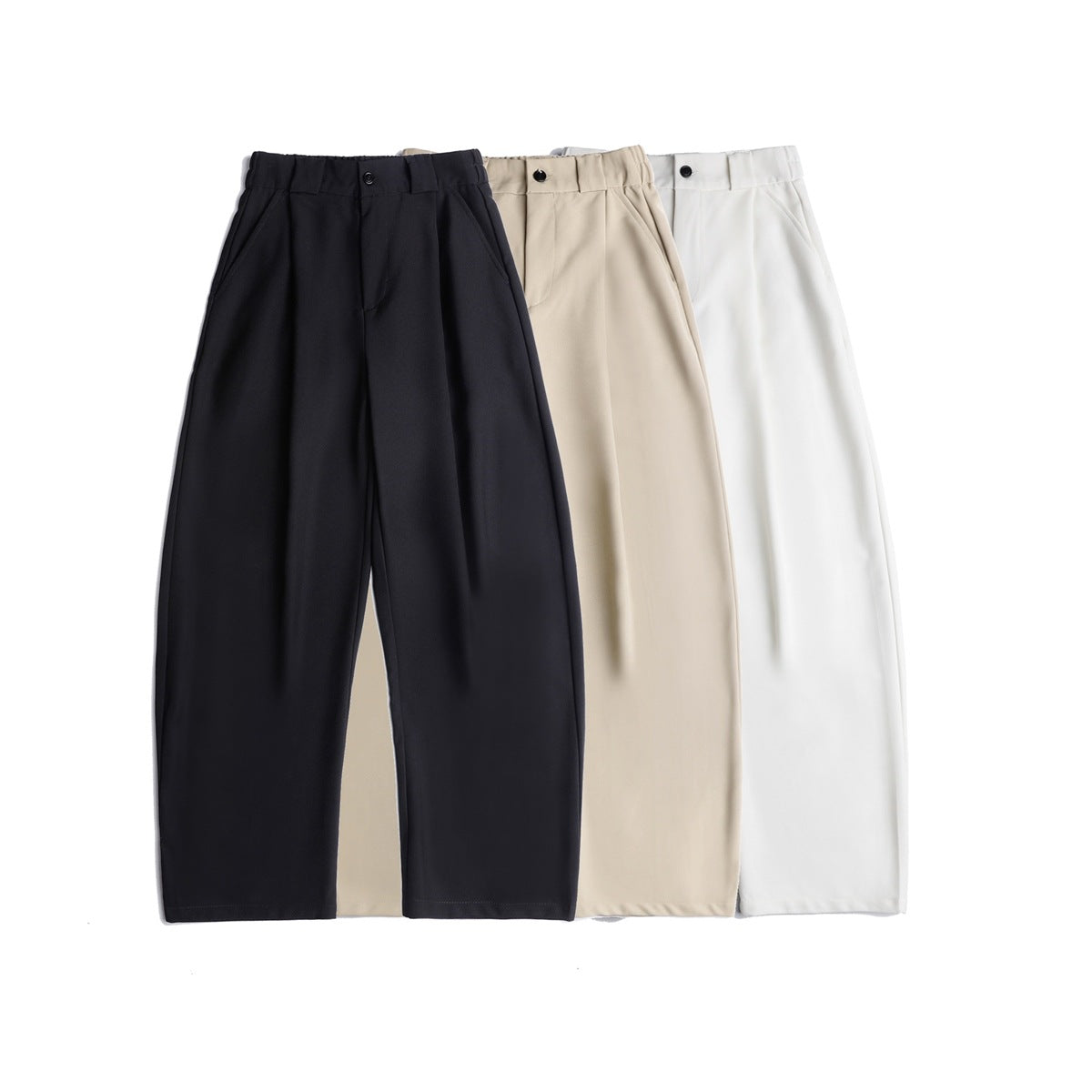 Three pairs of pleated, wide-leg trousers shown from the front in black, beige, and white.