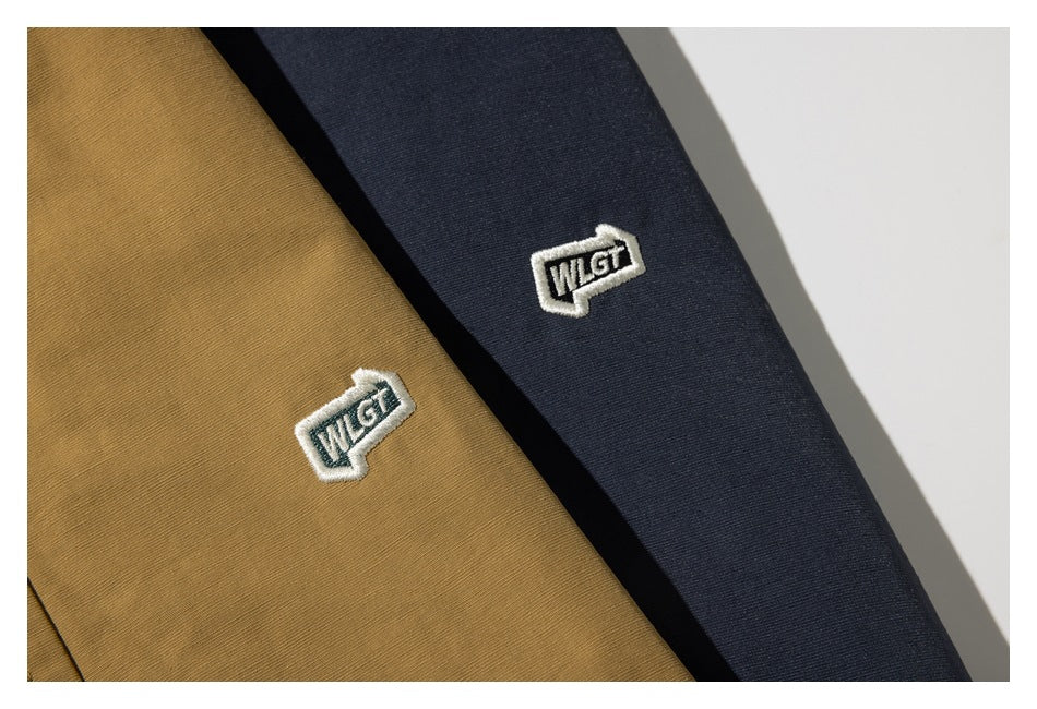 Embroidered patches on tan and navy jacket fabric.
