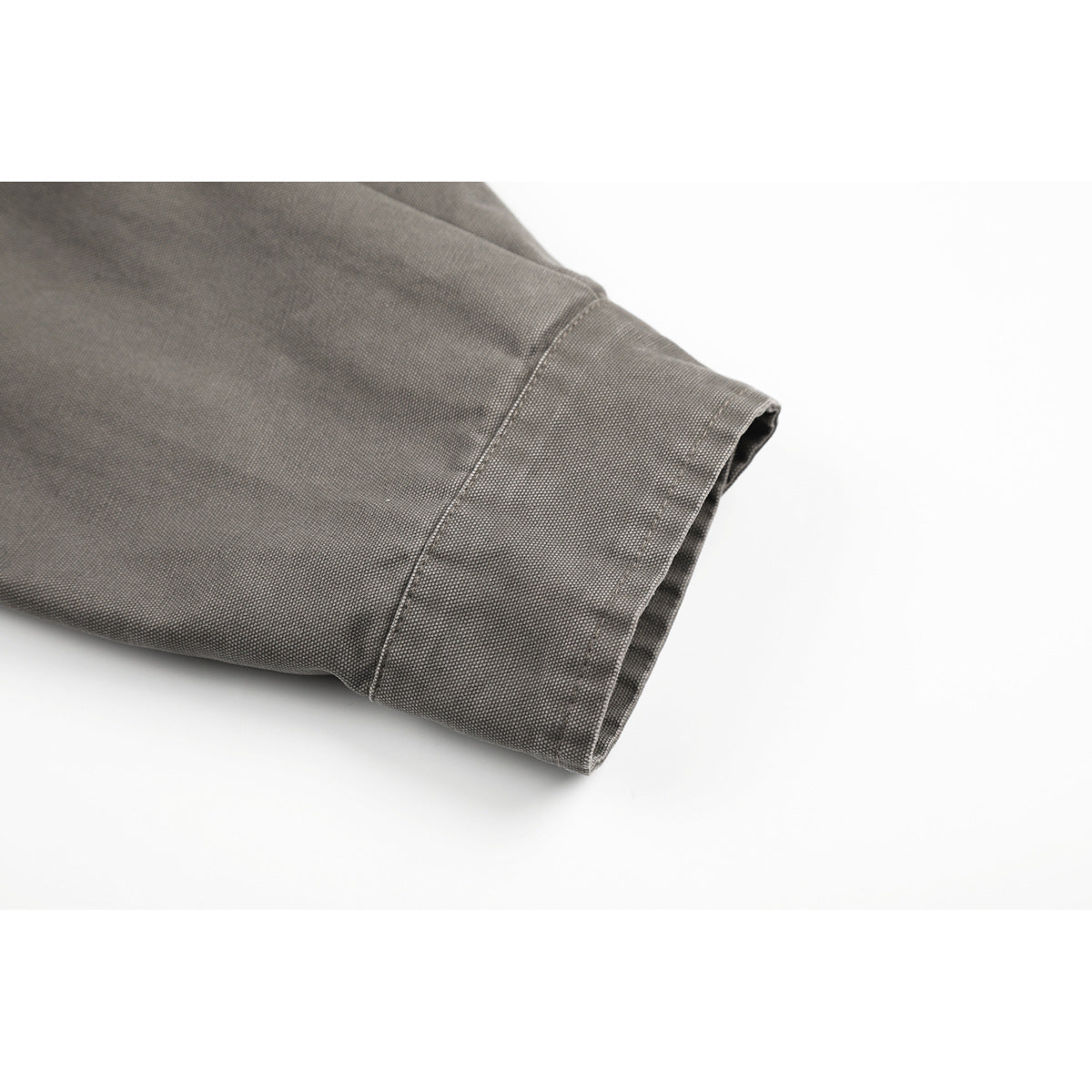 Close-up of a gray jacket sleeve ending in a wide stitched cuff.