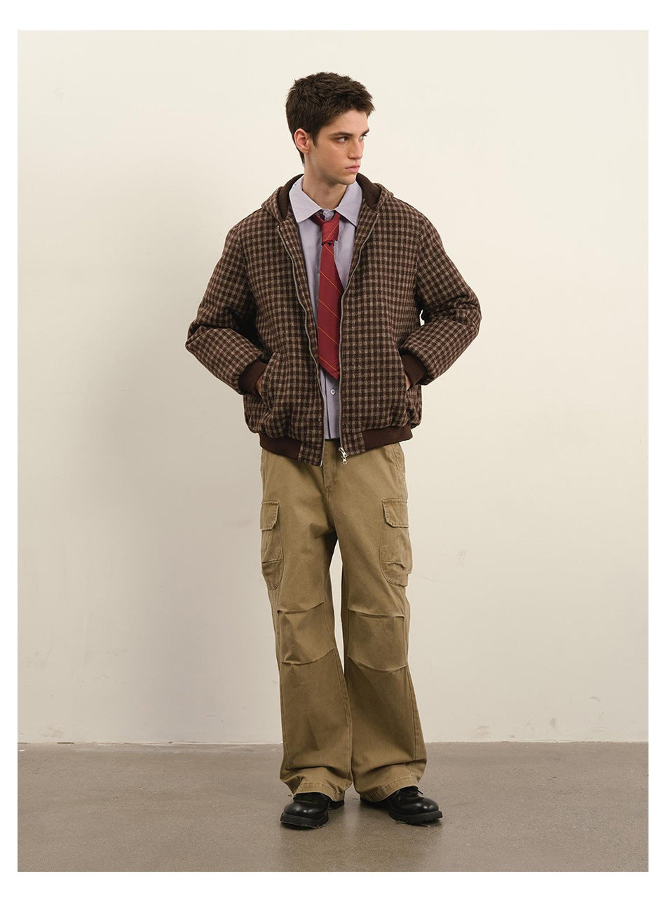 Model wearing a brown check hooded zip jacket over a lavender shirt, red tie and khaki cargo pants, hands in pockets