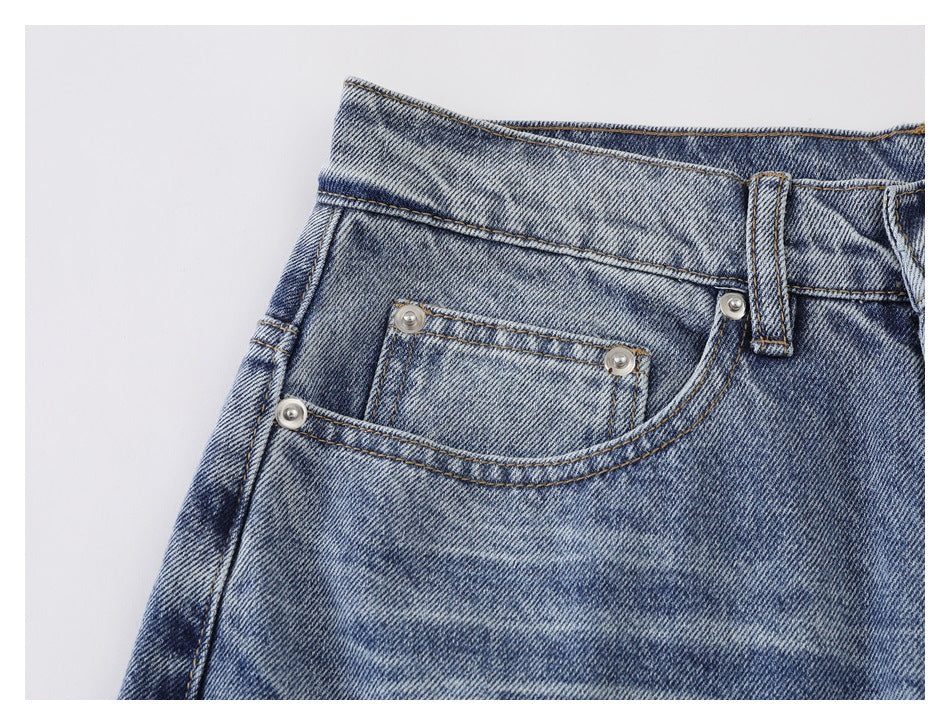Close-up of the front coin pocket with metal rivets, contrast stitching, and faded blue denim.