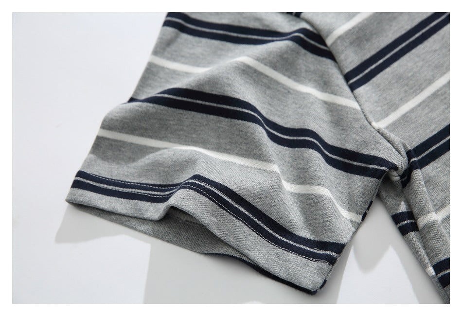 Close-up of a short sleeve and hem on the gray T-shirt with navy and white stripes.