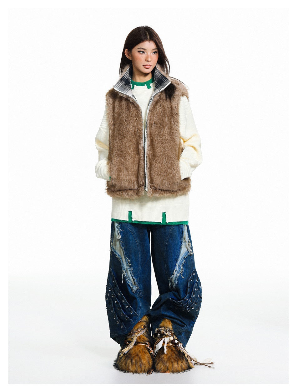 Model wearing an open brown shaggy vest with a plaid standing collar over an ivory sweater and wide blue jeans.