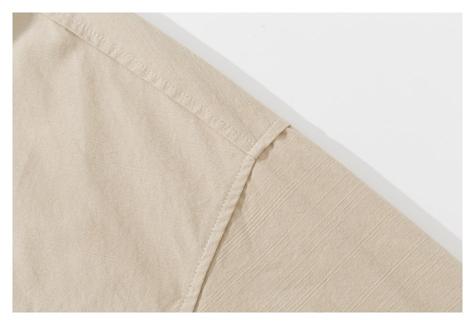 Close-up of a beige shirt's shoulder seam and sleeve construction.