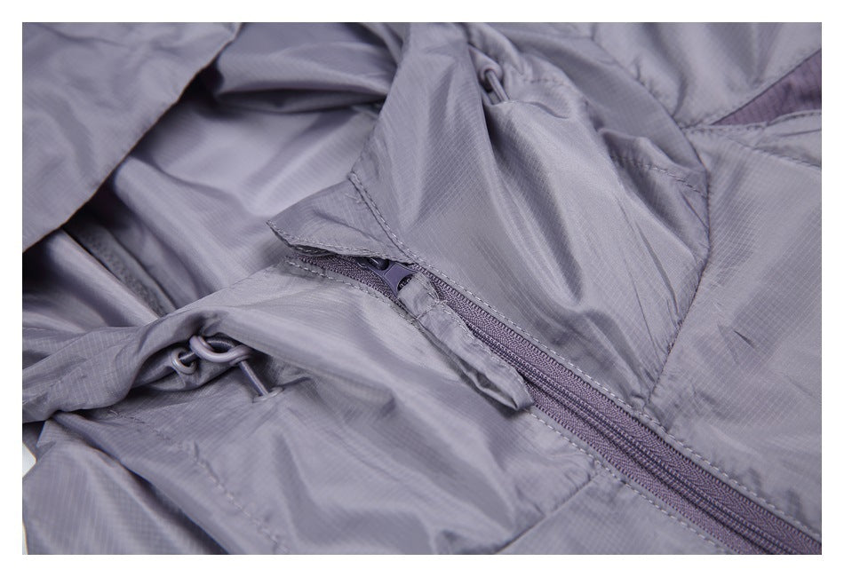 Close-up of the gray-lavender jacket's zipper, storm flap, and hood drawcord hardware.