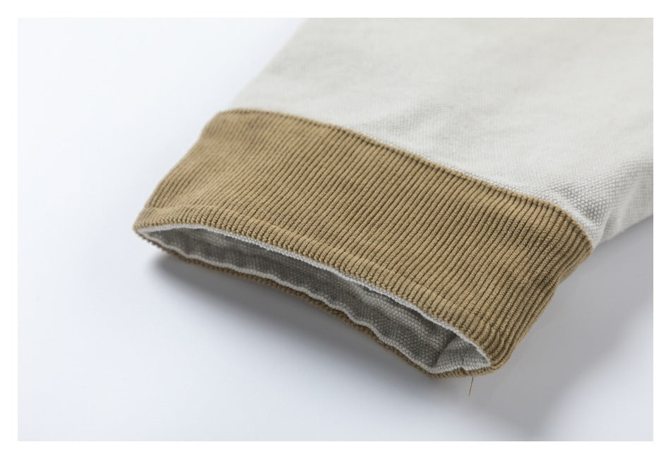Close-up of a tan ribbed cuff on a light gray garment.