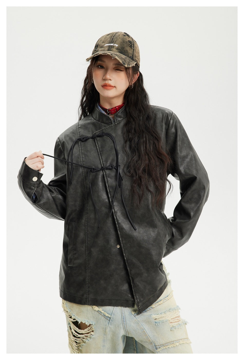 Model wears a black mottled stand-collar jacket with decorative front ties and snap cuffs.