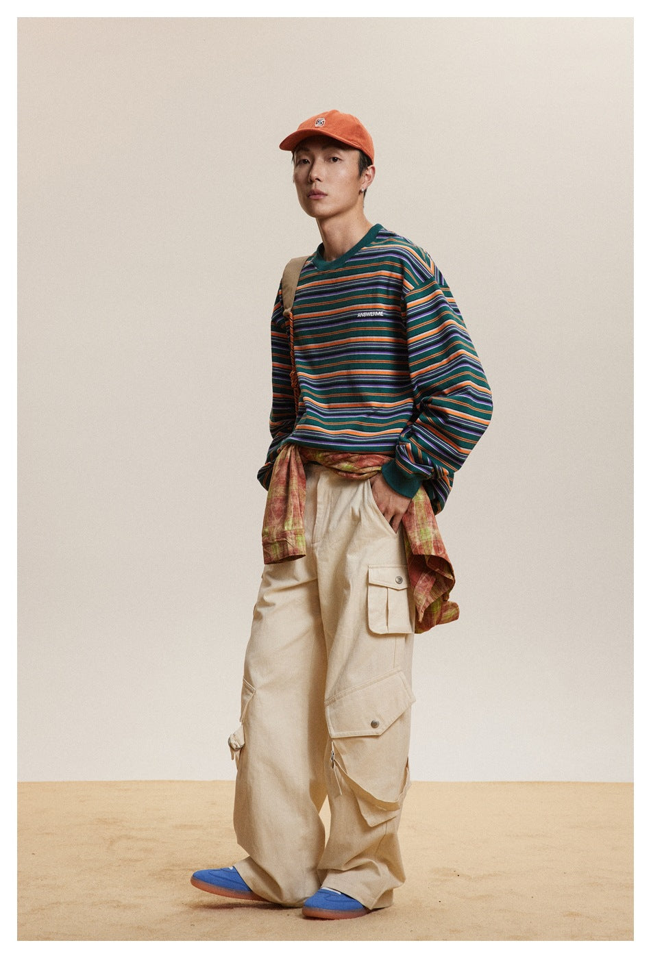 Three-quarter view of a model in a green shirt with orange, purple, and light-colored stripes.