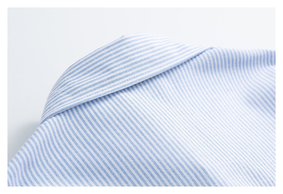 Close-up of a pointed collar on a white shirt with fine blue stripes.