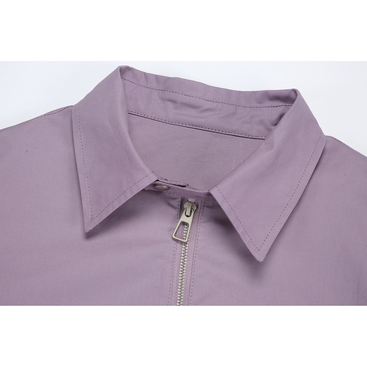 Close-up of a lavender jacket’s pointed collar and silver front zipper.