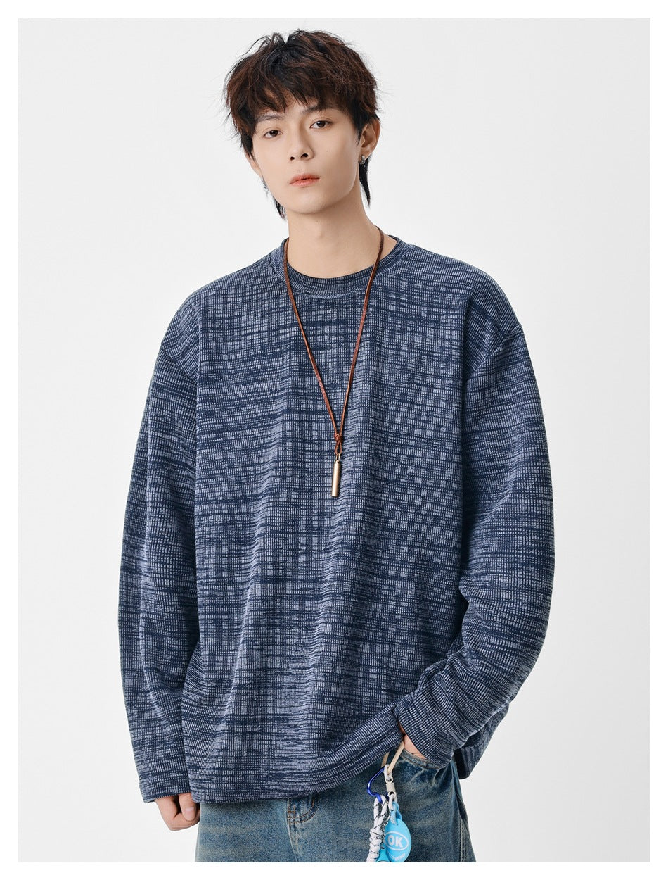 Model wearing an oversized blue-gray marled crewneck sweatshirt with long sleeves and a ribbed neckline.