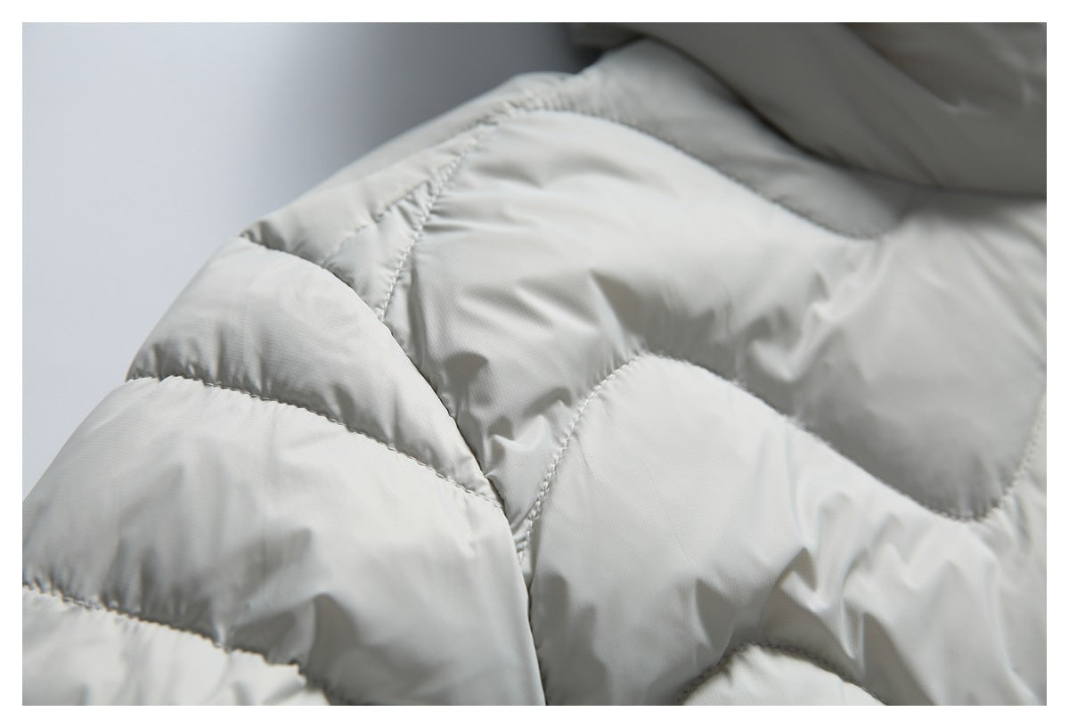 Close-up showing the curved stitched quilting on light gray jacket fabric.