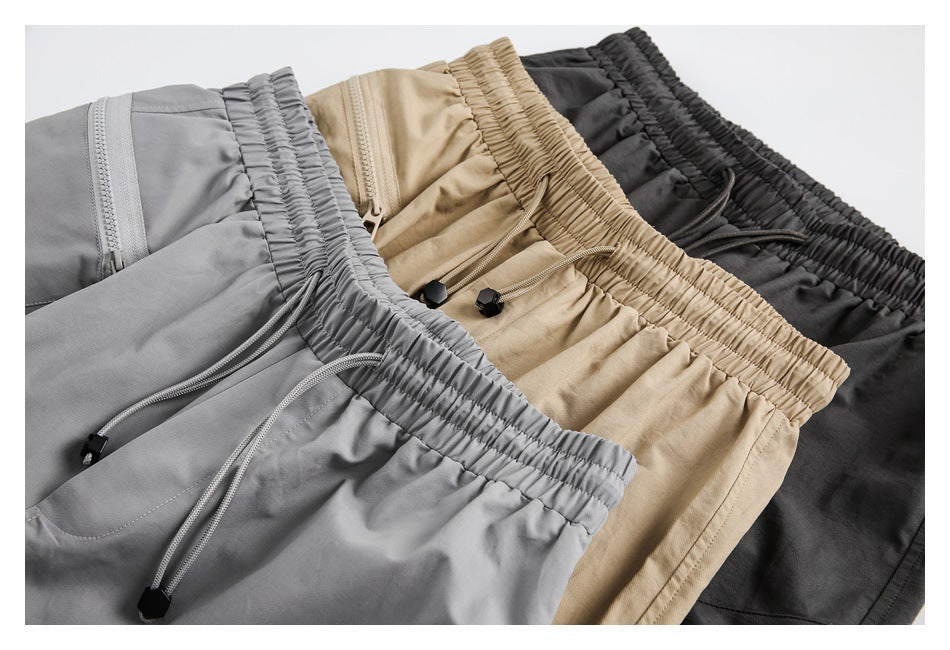Three pairs of casual pants in gray, beige, and black, shown close up with elastic waists and drawcords.