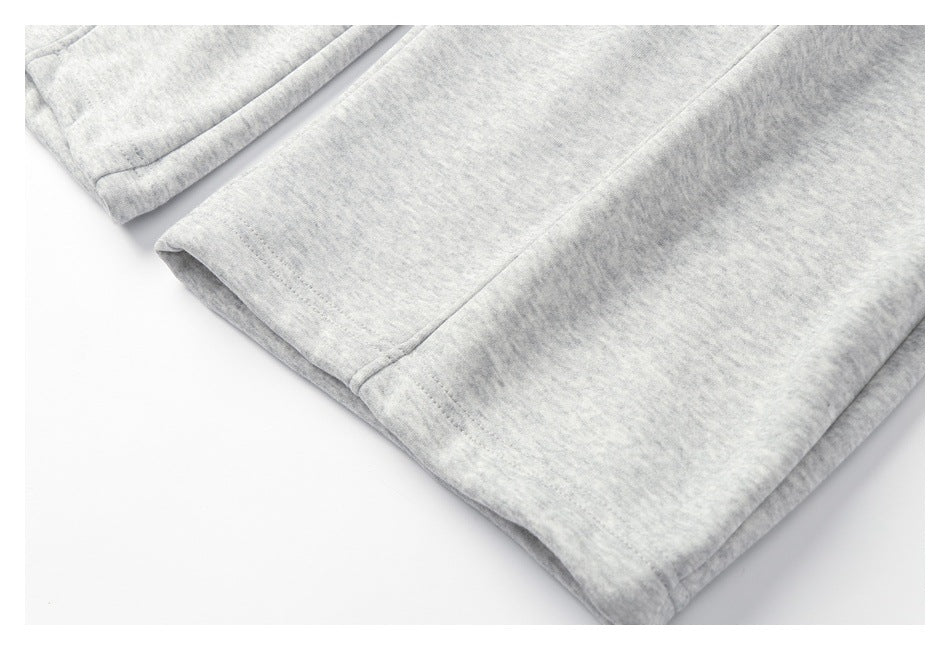 Close-up of the stitched leg hem and seam on light gray heathered sweatpants.