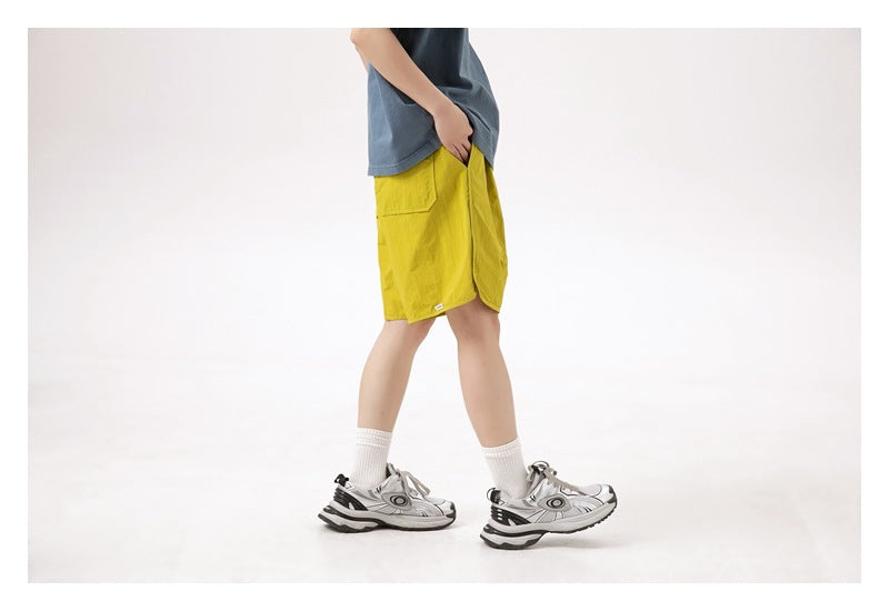 Side view of a person wearing bright yellow knee-length shorts with a blue-gray top.