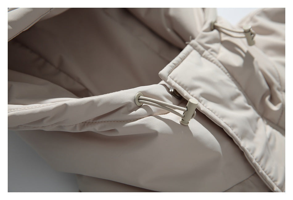 Close-up of a light beige jacket drawcord with an adjustable toggle.