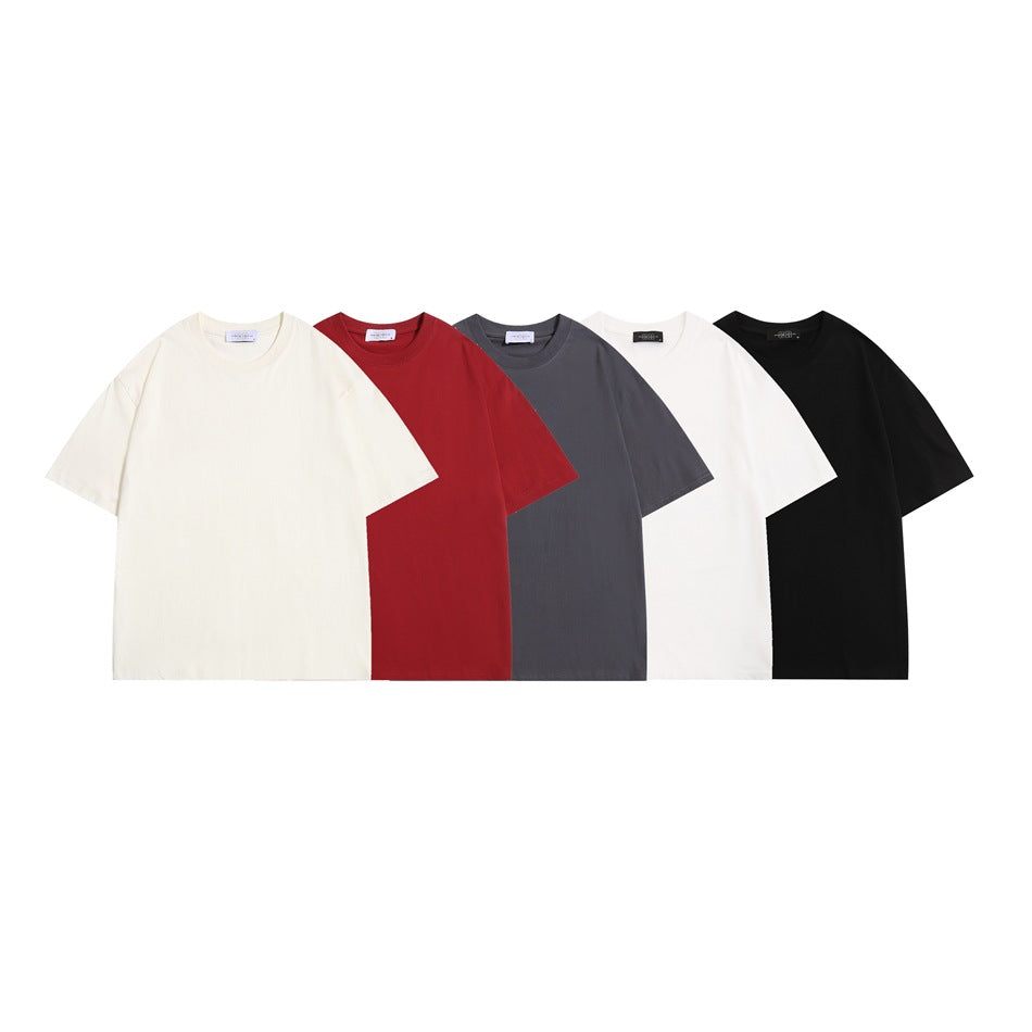 Five plain short-sleeve crew-neck T-shirts shown together in cream, red, charcoal gray, white, and black.