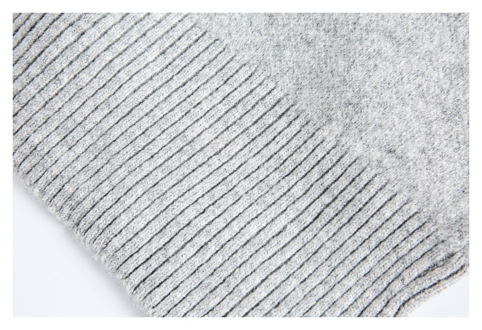 Close-up of a ribbed edge on light gray knit fabric.