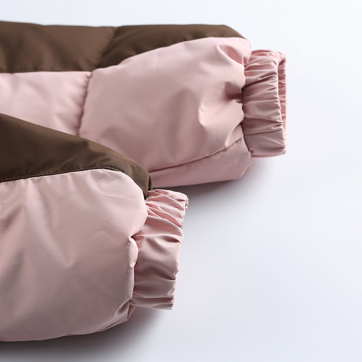 Close-up of the jacket's gathered pale pink sleeve cuffs and brown-and-pink color blocking.