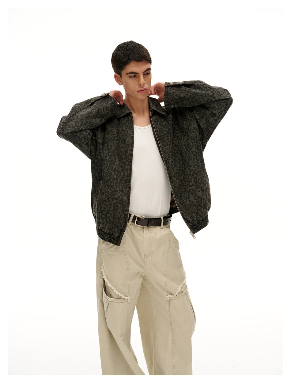 Model wearing an open dark olive leopard-print jacket over a white top, with loose beige trousers.