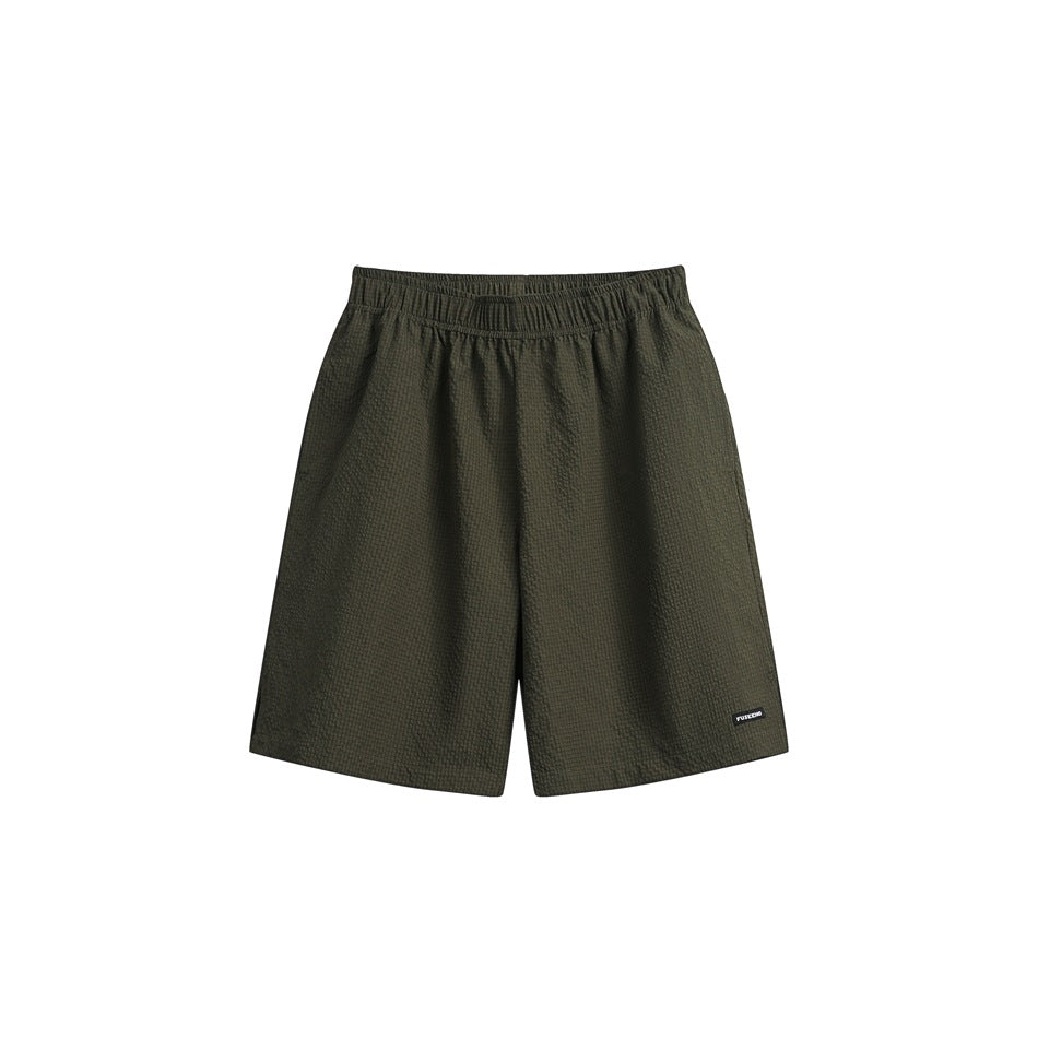 Olive green textured knee-length shorts with elastic waistband and small label, flat front view