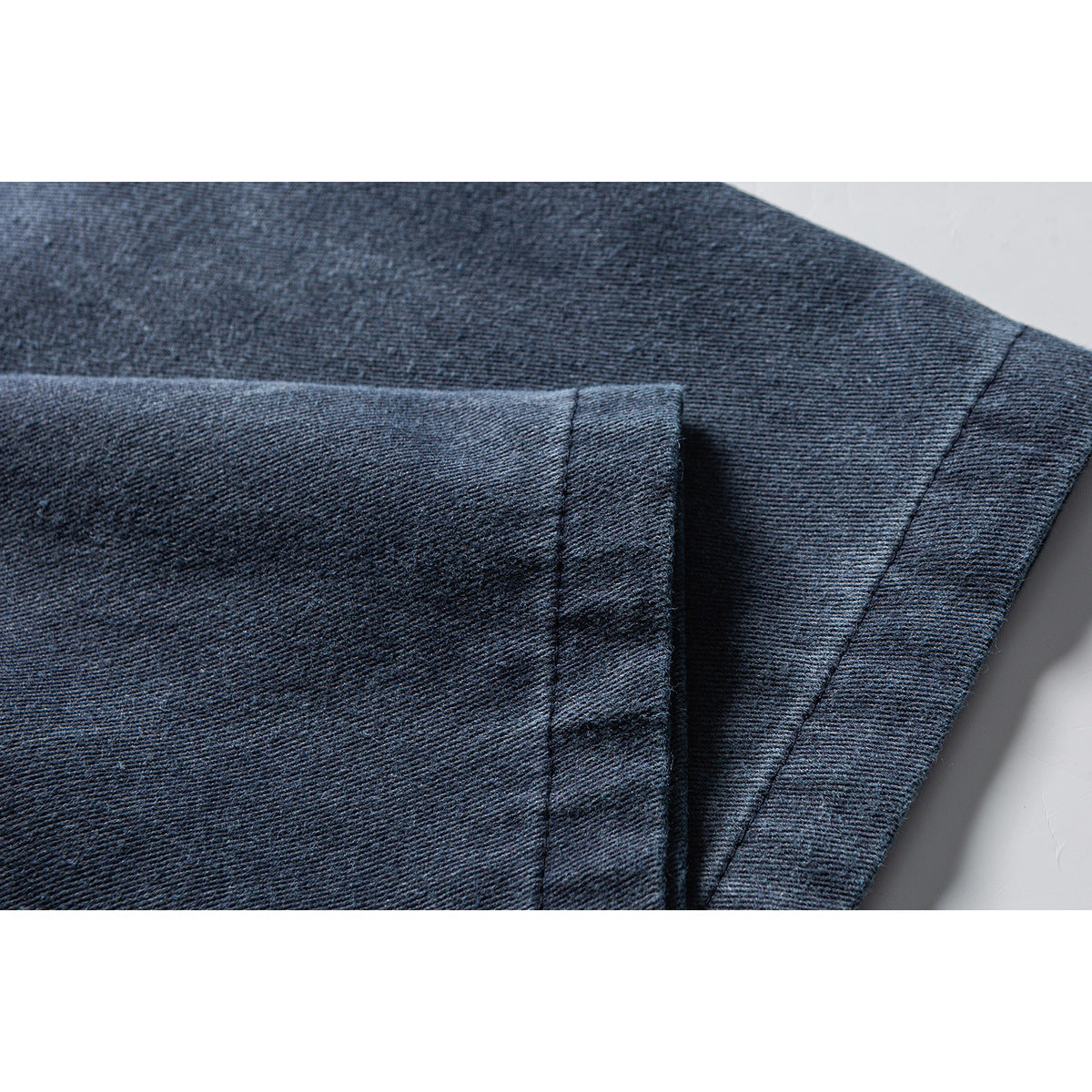 Close-up of the dark blue shirt's sleeve and stitched cuff.