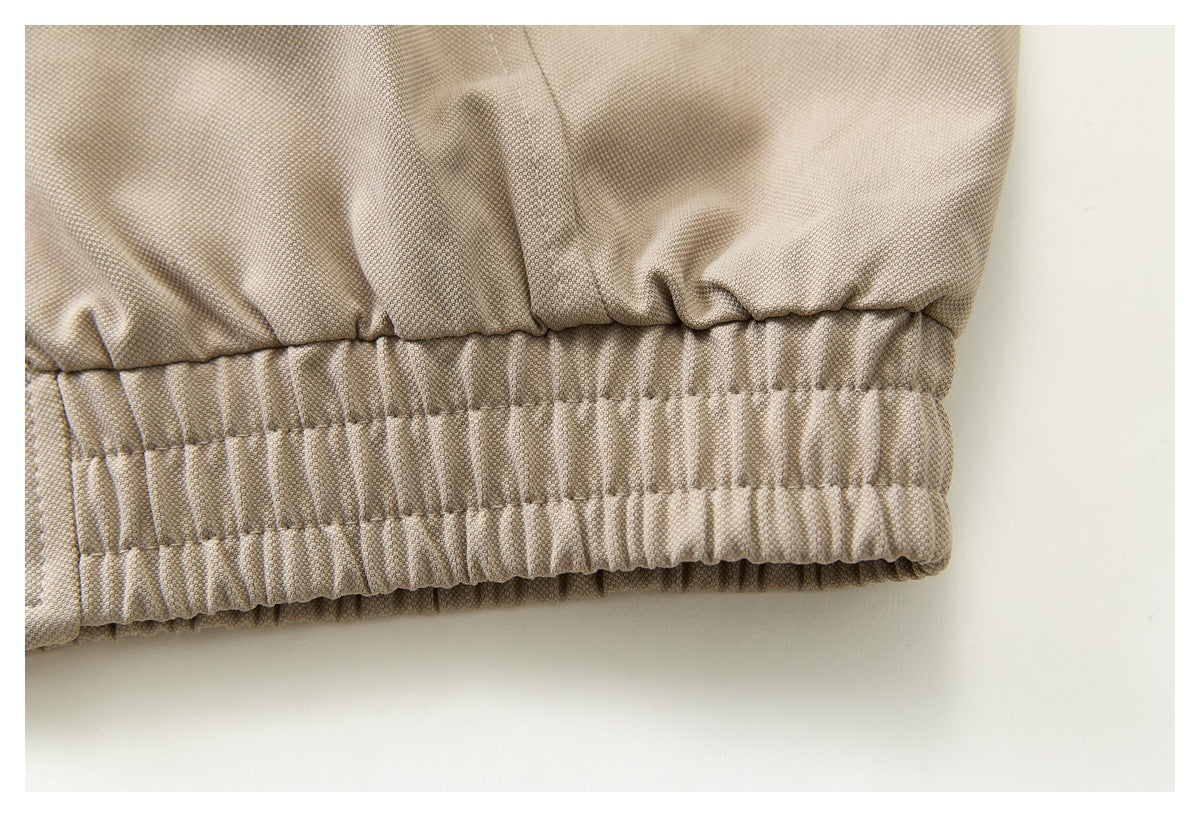 Close-up of beige garment fabric showing a gathered, elasticized hem.
