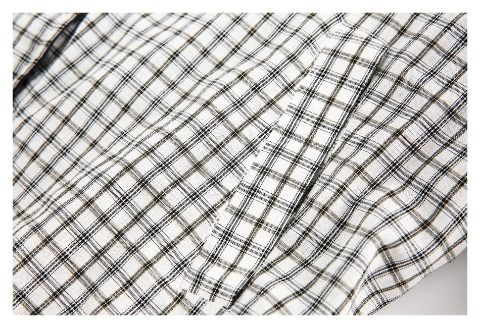 Close-up of white-and-black plaid fabric with a narrow stitched opening or pocket detail.