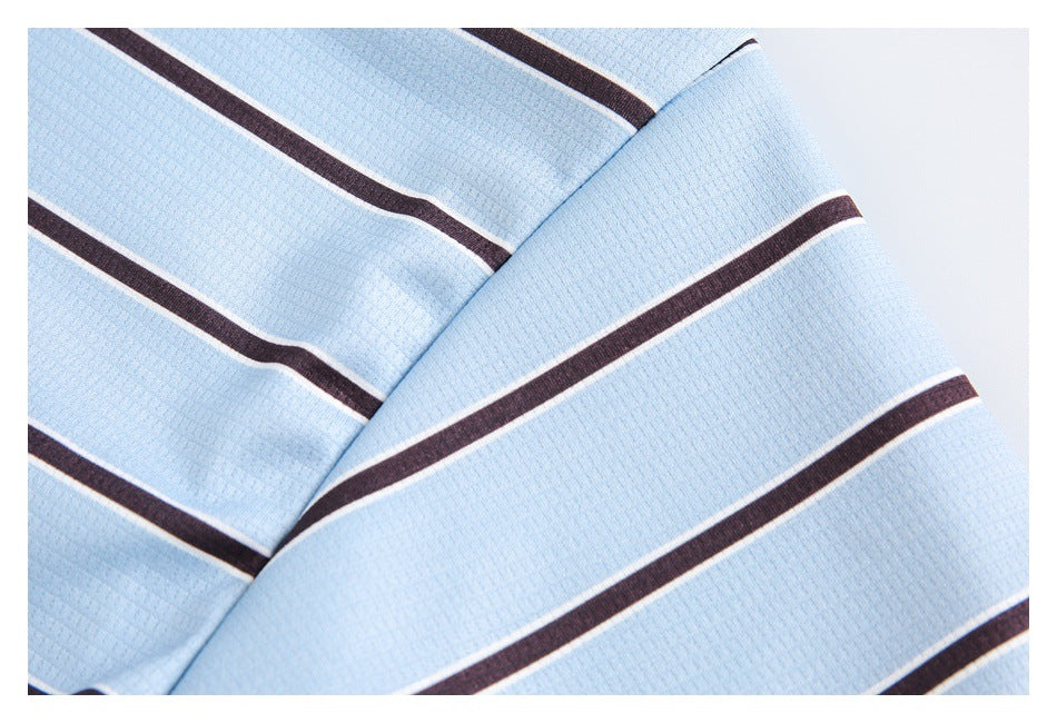 Close-up of pale blue textured fabric with dark brown and thin white horizontal stripes, folded diagonally.