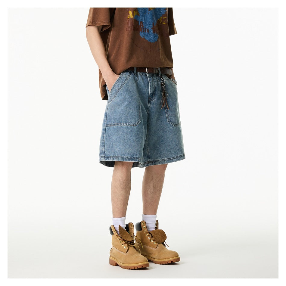 Front three-quarter view of a person wearing loose light-wash denim shorts with large front pockets.