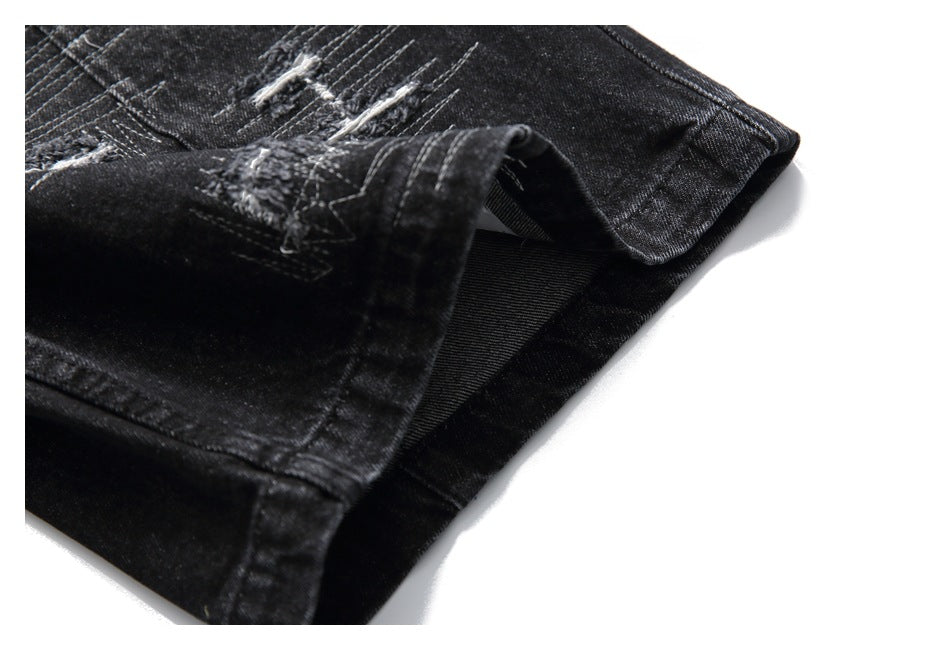 Close-up of the black denim shorts' folded leg hem and distressed stitching.
