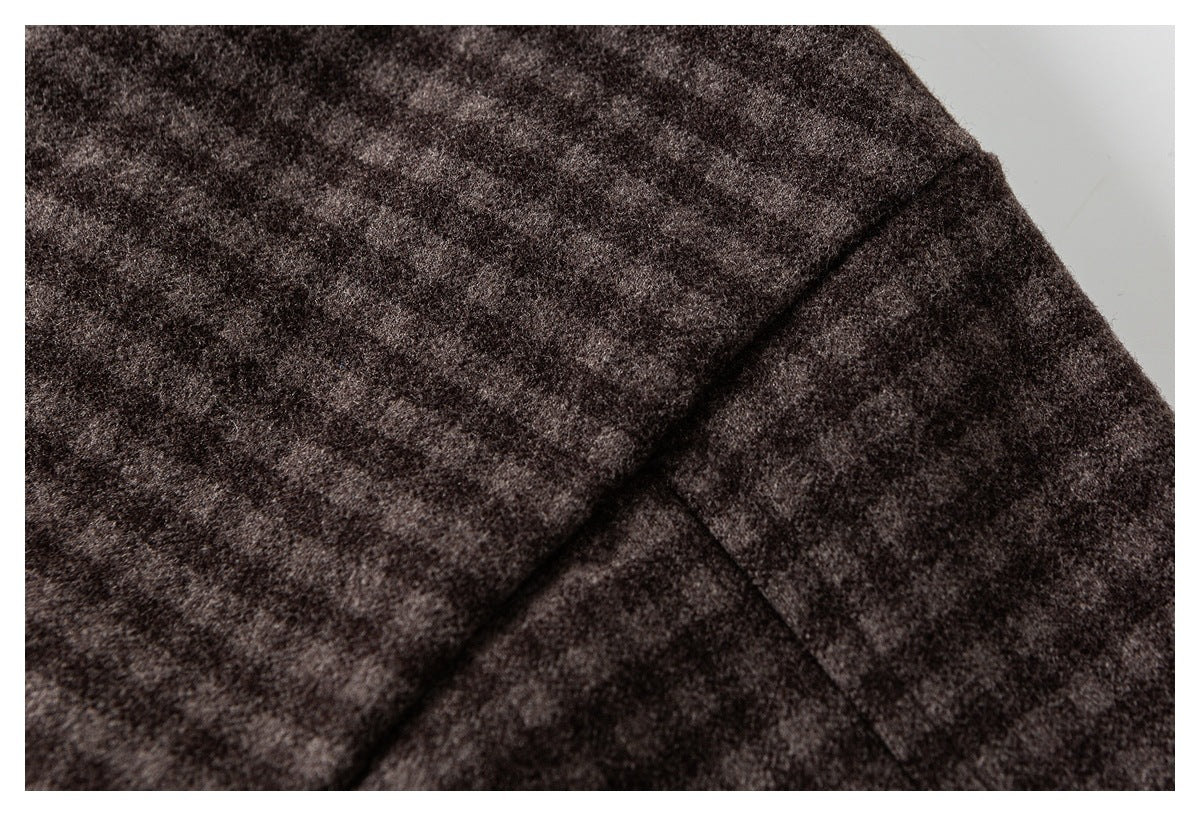 Close-up of a stitched seam across dark brown mottled coat fabric.