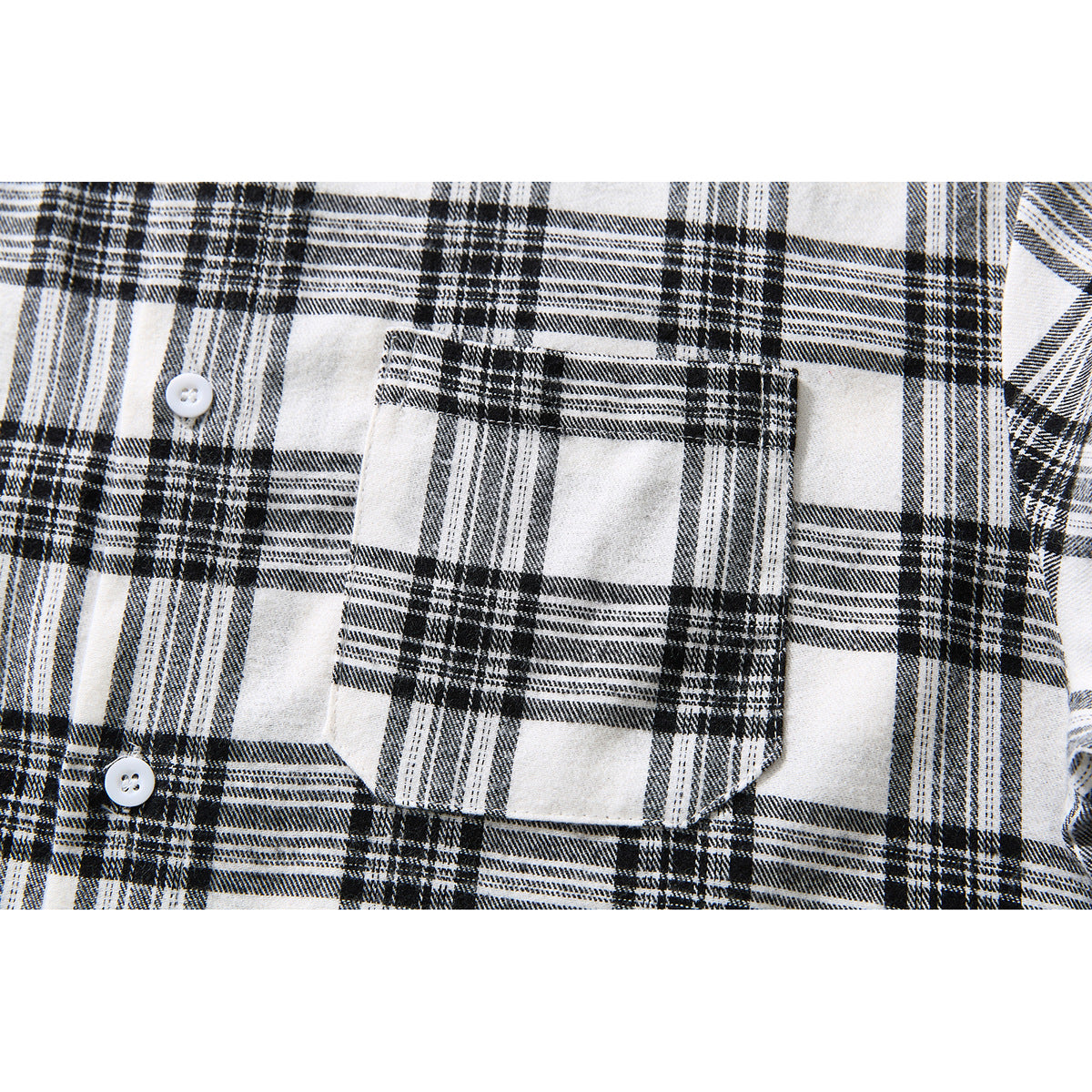 Close-up of a black-and-white plaid shirt's buttoned chest pocket and front buttons.