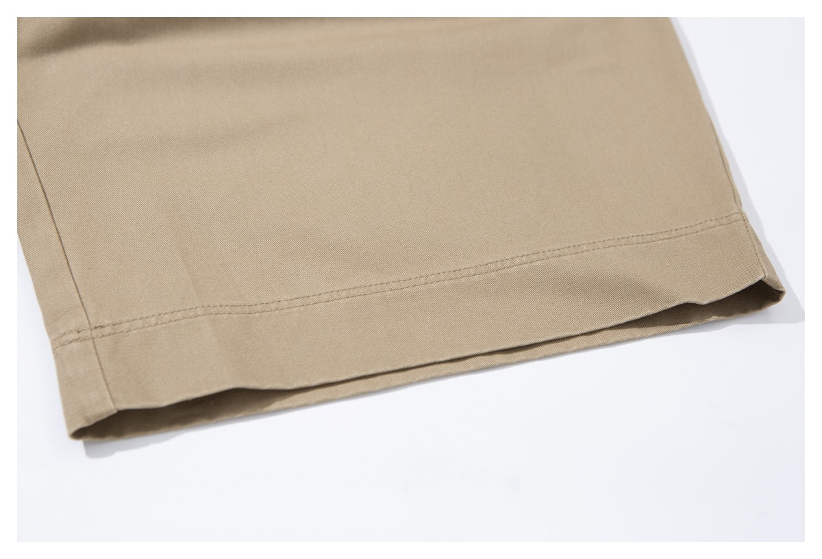 Close-up of the double-stitched hem on a tan trouser leg.