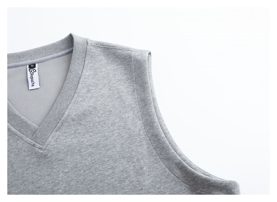 Close-up of the light gray vest's ribbed V-neck, shoulder seam, and armhole binding.