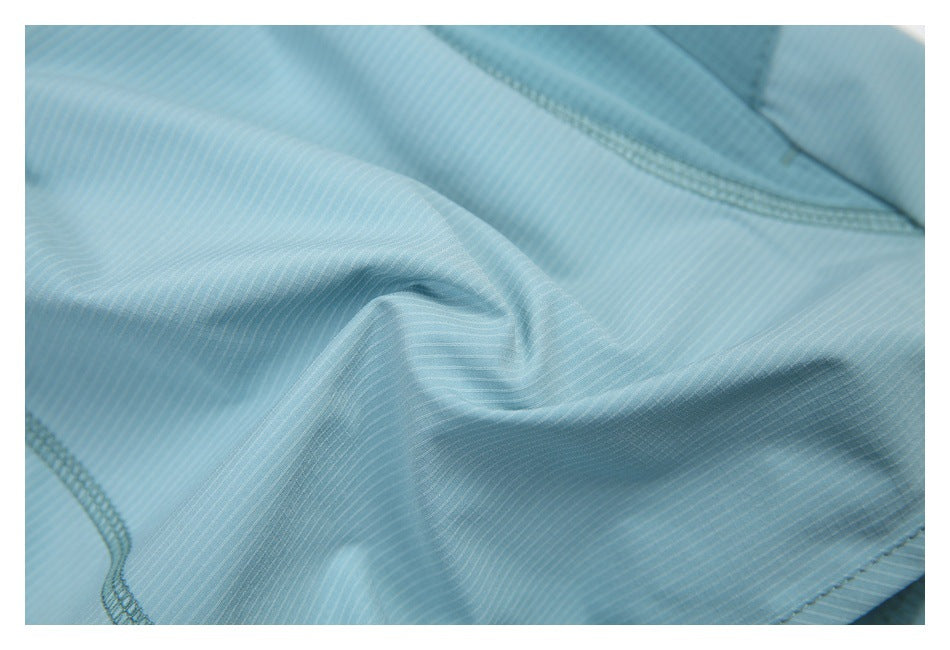 Close-up of light blue shorts fabric with fine stripes and overlocked seams.