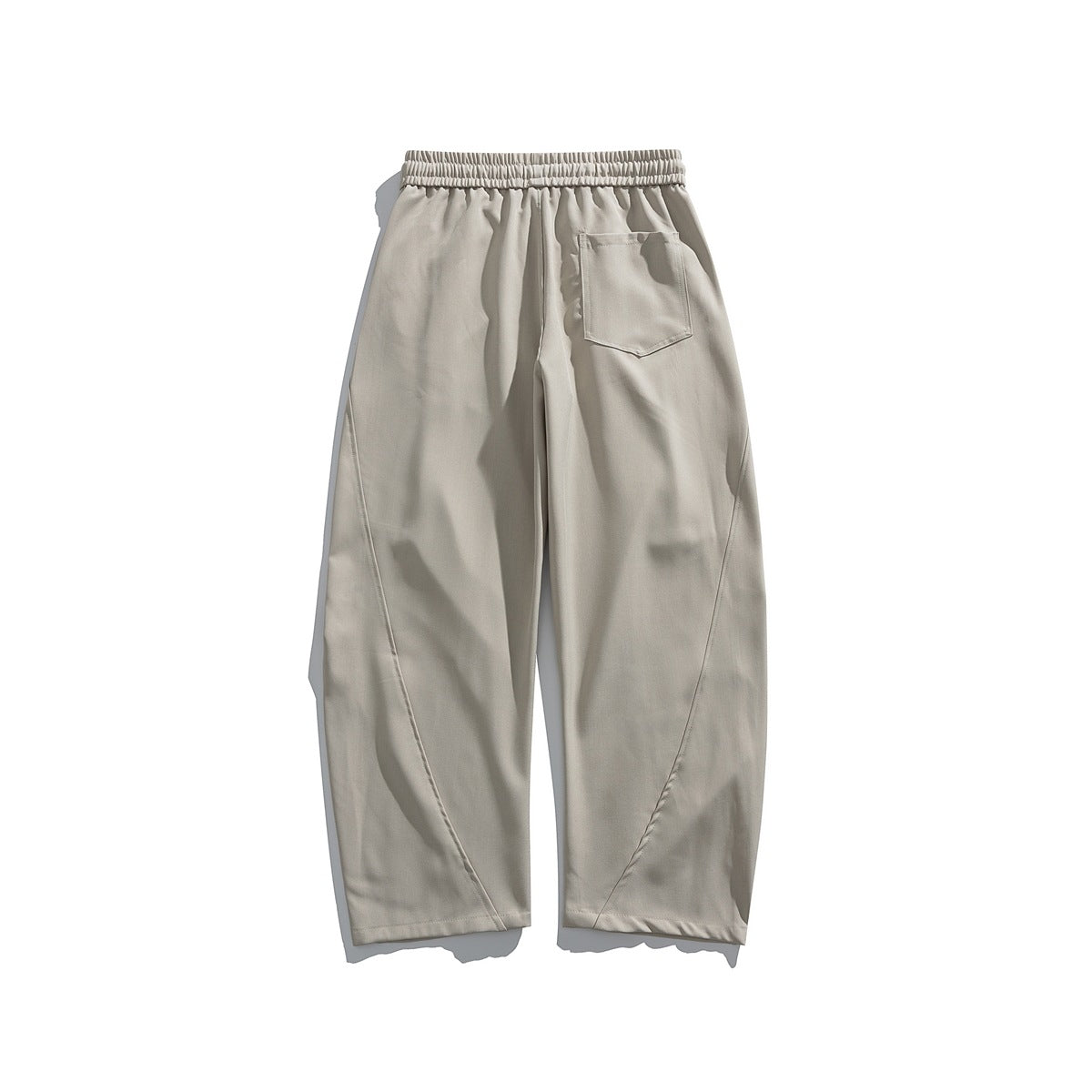 Back view of light beige loose straight-leg trousers with an elastic waistband and a single patch pocket.