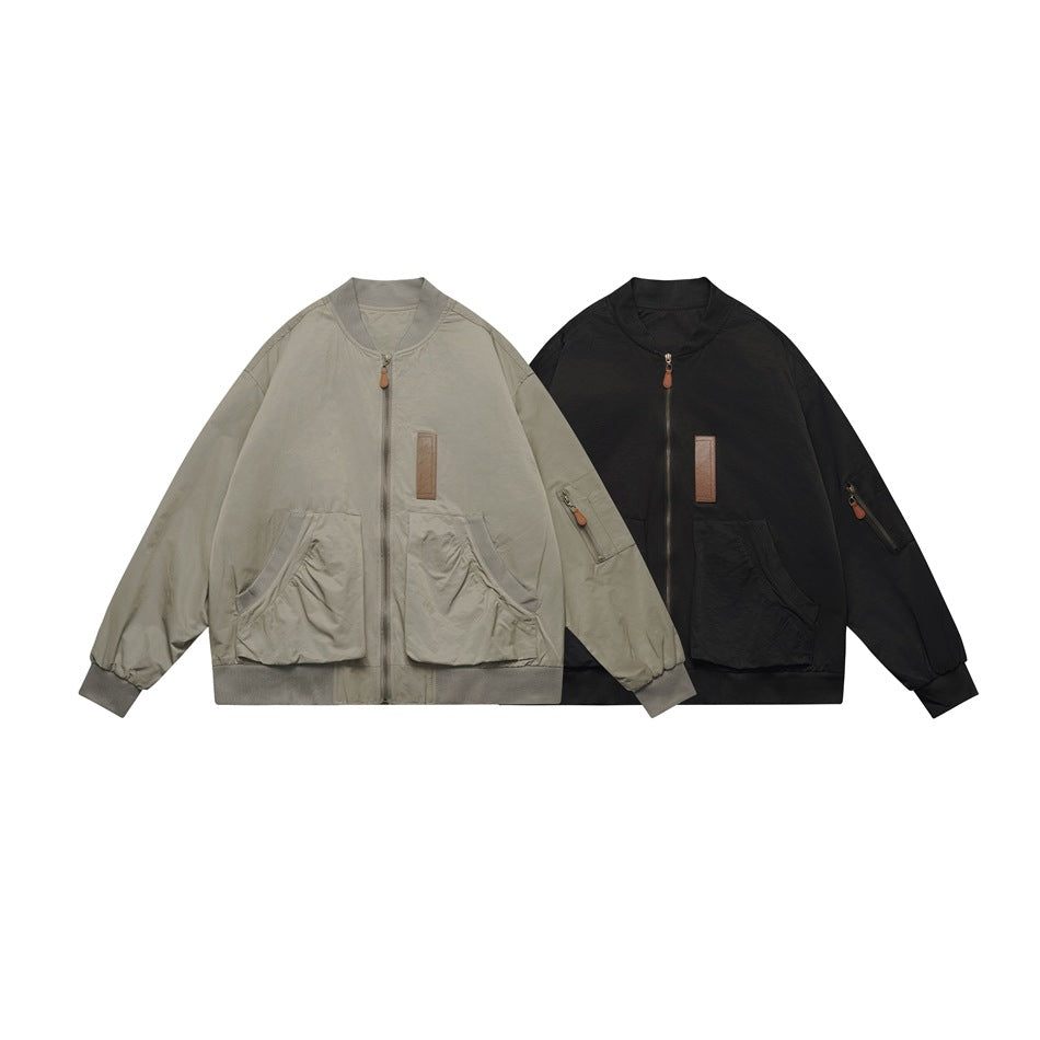 Two zip-front jackets shown together: one light gray-beige and one black, both with ribbed trims and front pockets.