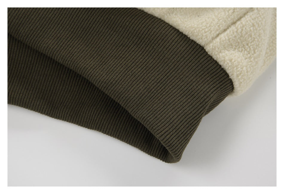 Close-up of a dark olive ribbed jacket cuff beside cream fleece fabric.