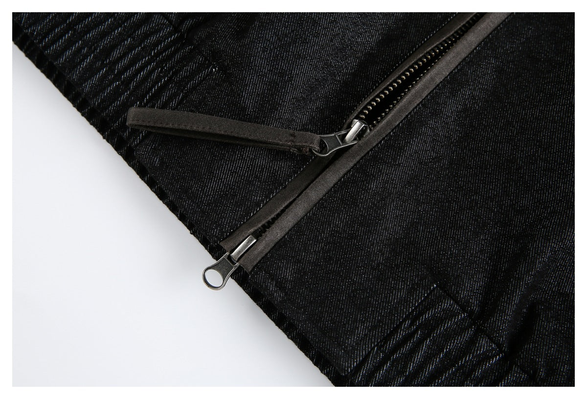 Close-up of a diagonal zipper with metal pulls on black garment fabric.
