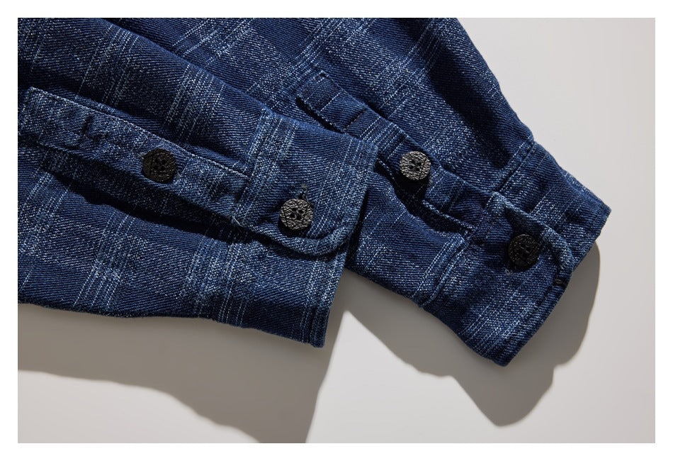Close-up of the blue plaid shirt sleeve cuffs with dark buttons.