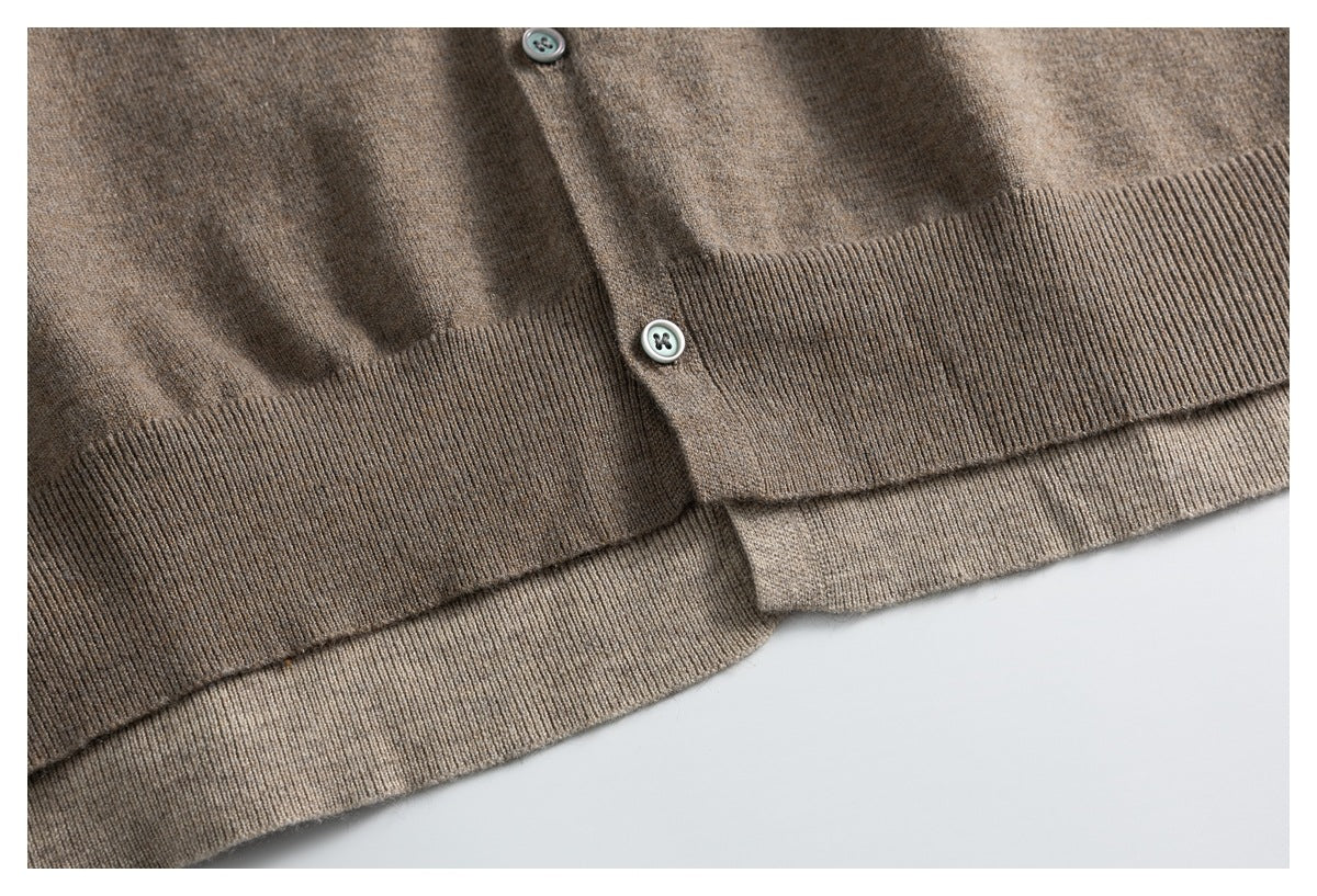 Close-up of the cardigan's taupe ribbed hem and button placket, with the hem folded over.