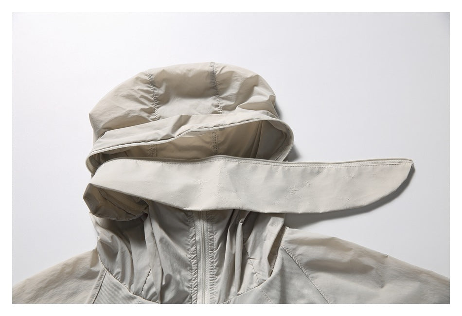 Close-up of a light beige jacket's hood, wide brim, and front zipper.