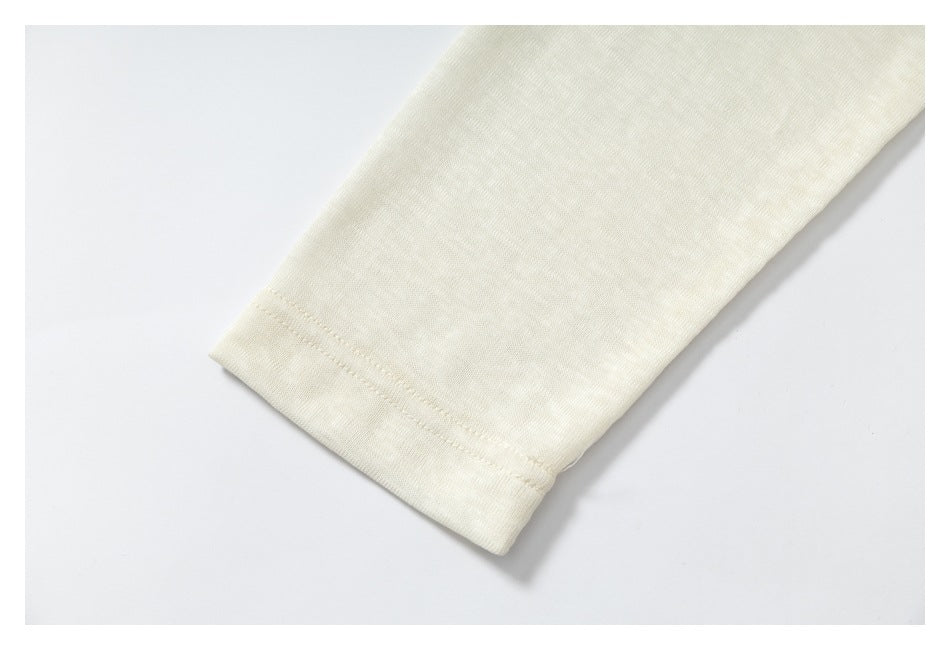 Close-up of an ivory sleeve cuff with a narrow stitched hem.