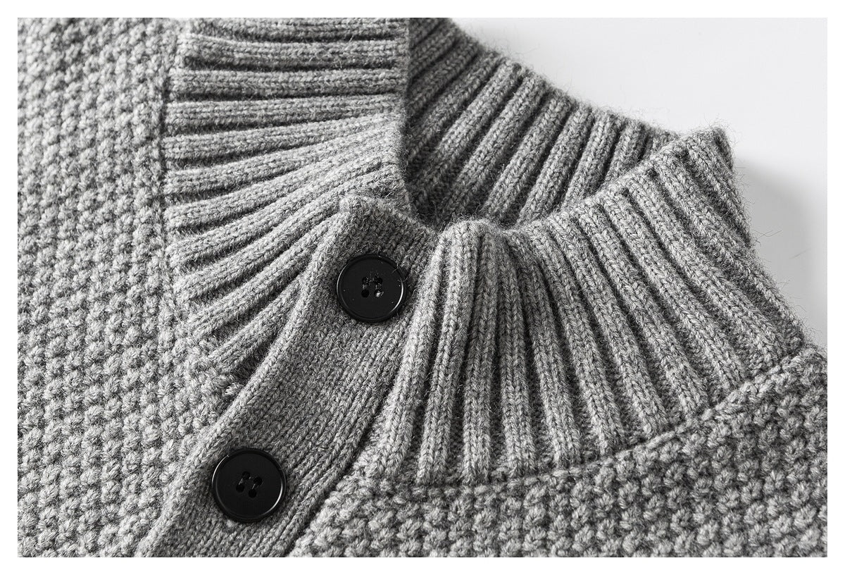 Close-up of a gray textured knit cardigan collar, ribbed placket, and two black buttons.
